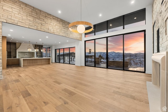 2738 Longspur Ln, Park City, UT 84098 - unfurnished living room with a high ceiling, a mountain view, and light hardwood / wood-style flooring