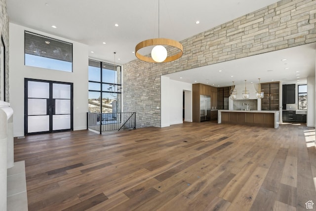 2738 Longspur Ln, Park City, UT 84098 - unfurnished living room featuring dark wood-type flooring, sink, french doors, and a high ceiling