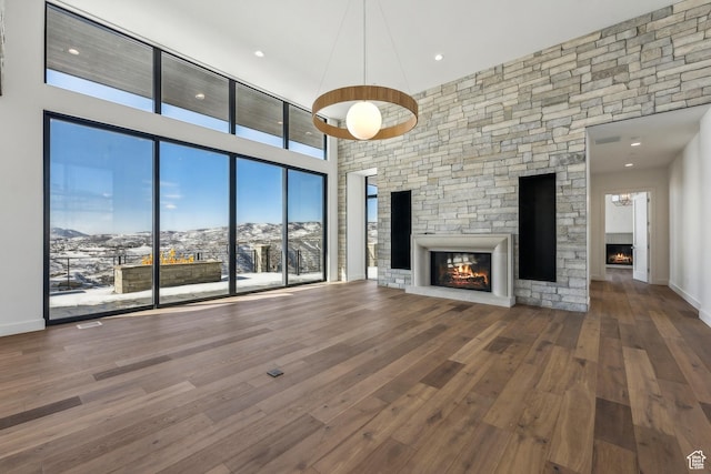 2738 Longspur Ln, Park City, UT 84098 - unfurnished living room featuring a towering ceiling, a fireplace, a mountain view, and hardwood / wood-style floors