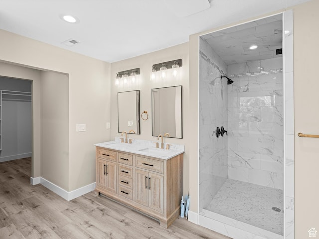 bathroom with vanity, tiled shower, and hardwood / wood-style floors