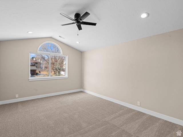 carpeted empty room featuring ceiling fan and lofted ceiling