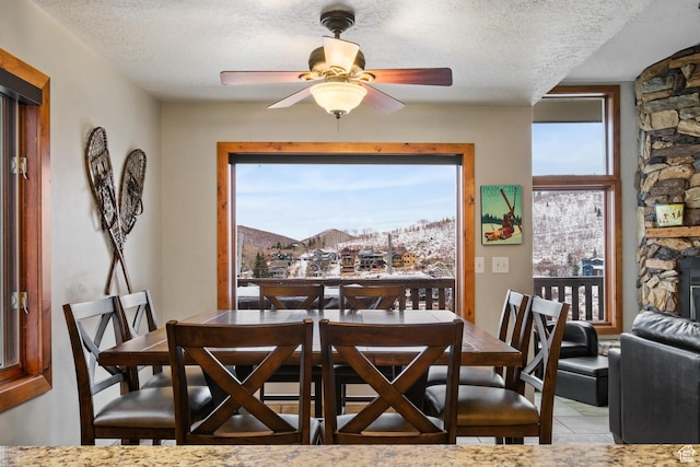 236 Norfolk Ave, Park City, UT 84060 - dining room featuring ceiling fan, a stone fireplace, and a textured ceiling