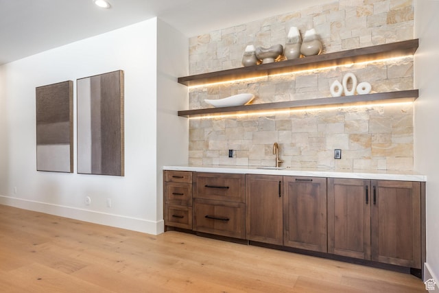 9791 N Uinta Dr, Kamas, UT 84036 - bar with backsplash, a sink, bar, baseboards, and light wood-style floors