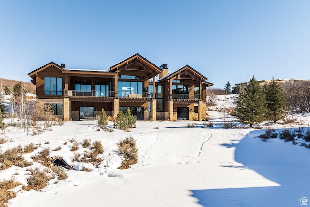 9791 N Uinta Dr, Kamas, UT 84036 - snow covered rear of property with stone siding and a chimney