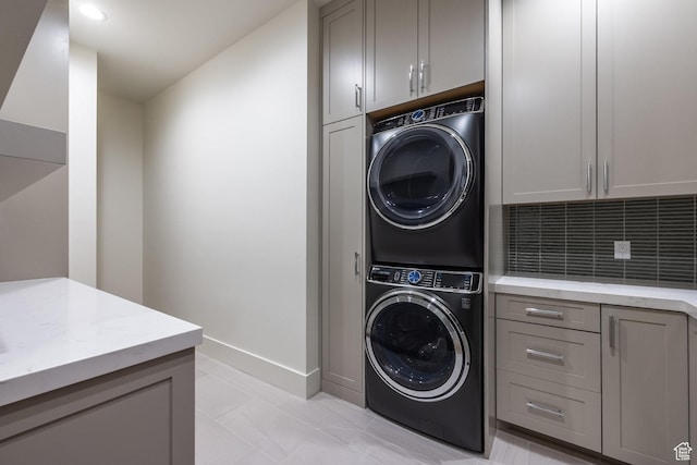 9791 N Uinta Dr, Kamas, UT 84036 - clothes washing area featuring cabinet space, baseboards, and stacked washing maching and dryer