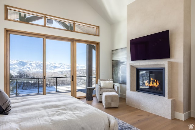 9791 N Uinta Dr, Kamas, UT 84036 - bedroom featuring high vaulted ceiling, access to exterior, wood finished floors, and a glass covered fireplace