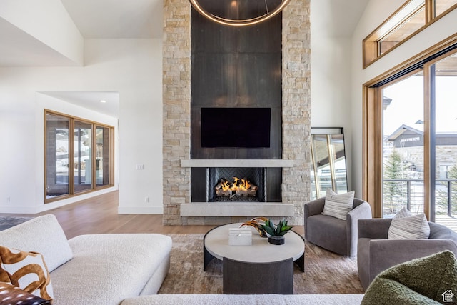 9791 N Uinta Dr, Kamas, UT 84036 - living room with a stone fireplace, baseboards, a high ceiling, and wood finished floors