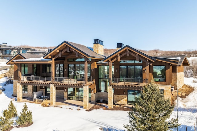 9791 N Uinta Dr, Kamas, UT 84036 - snow covered house with stone siding, a chimney, and a patio area