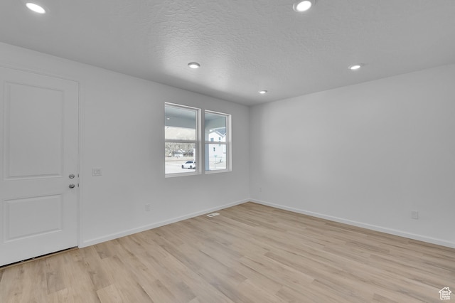 1946 E Burger St Unit 1237, Lake Point, UT 84074 - empty room with light wood-style flooring, recessed lighting, baseboards, and a textured ceiling