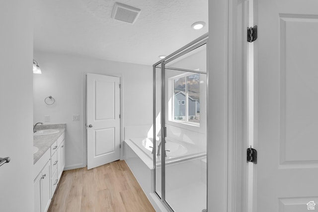 1946 E Burger St Unit 1237, Lake Point, UT 84074 - bathroom featuring double vanity, a garden tub, wood finished floors, a textured ceiling, and a stall shower