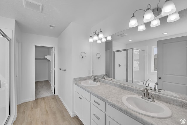 1946 E Burger St Unit 1237, Lake Point, UT 84074 - bathroom with a stall shower, a walk in closet, double vanity, wood finished floors, and baseboards