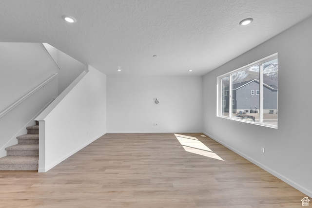 1946 E Burger St Unit 1237, Lake Point, UT 84074 - unfurnished living room with a textured ceiling, baseboards, light wood-type flooring, stairs, and recessed lighting