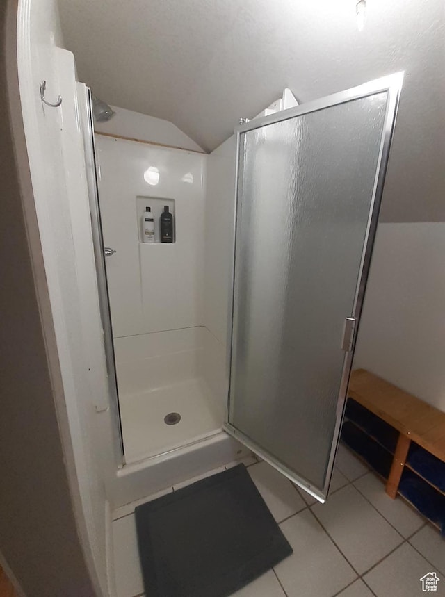 full bath featuring vaulted ceiling, a shower stall, and tile patterned floors