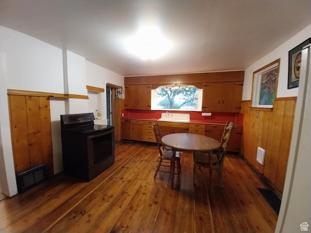 dining space with wooden walls, hardwood / wood-style floors, visible vents, and wainscoting