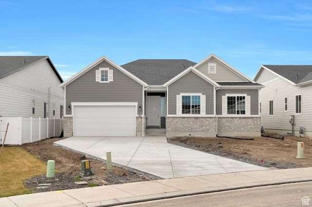 craftsman inspired home with a garage, brick siding, driveway, and fence