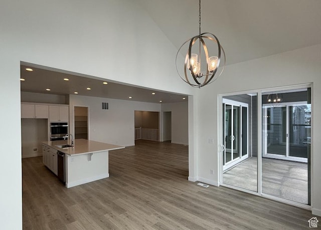 283 E Polaris Dr Unit 102, Saratoga Springs, UT 84045 - kitchen with visible vents, a sink, white cabinets, open floor plan, and a chandelier