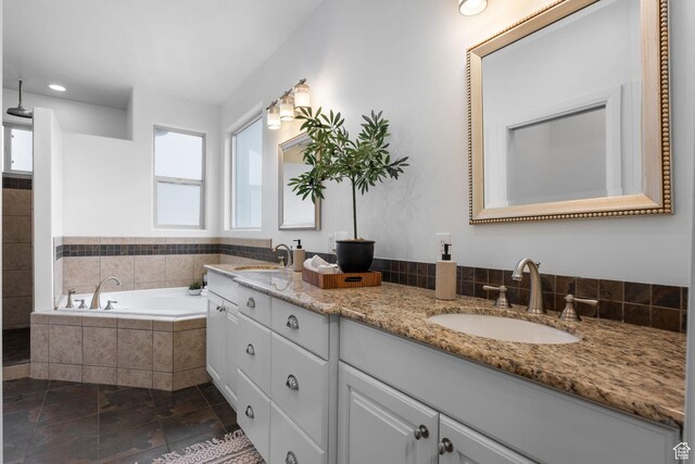 bathroom featuring vanity and tiled bath
