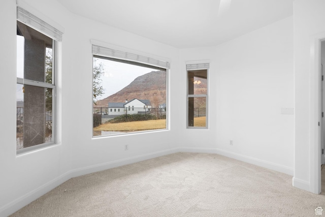 carpeted empty room featuring a mountain view