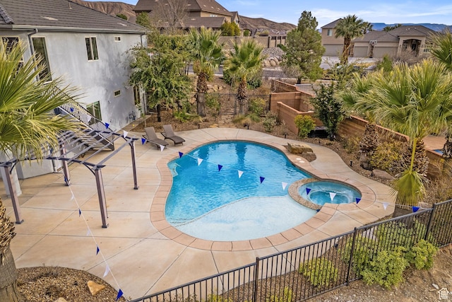 view of pool with an in ground hot tub, a mountain view, and a patio area
