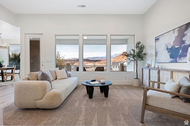 living room with an inviting chandelier, carpet floors, and a mountain view