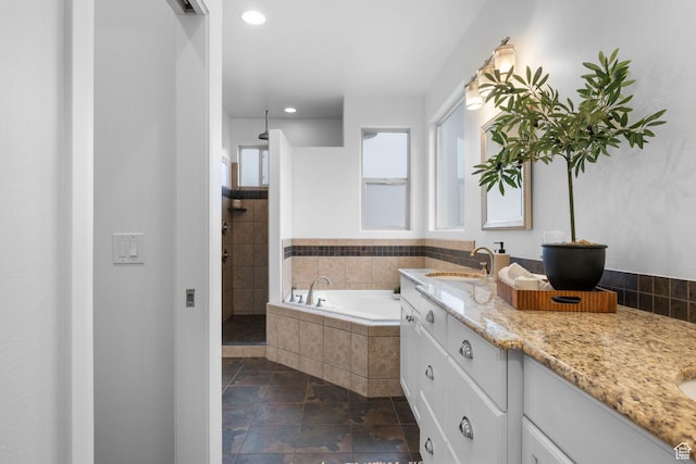 bathroom featuring plus walk in shower and vanity