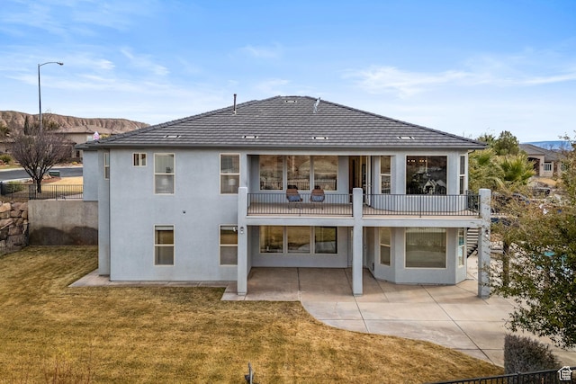back of property with a yard and a patio area