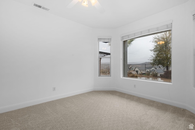 unfurnished room with ceiling fan and carpet
