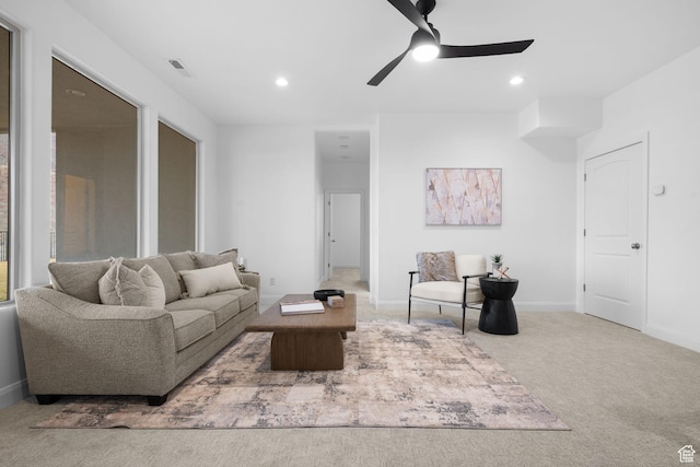 carpeted living room with ceiling fan