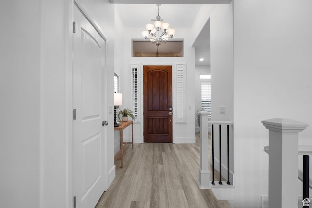 entryway featuring an inviting chandelier and light hardwood / wood-style flooring