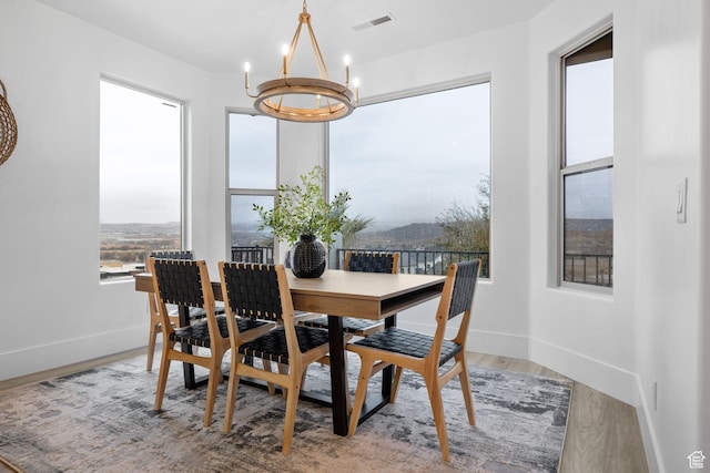 dining space with hardwood / wood-style floors and an inviting chandelier