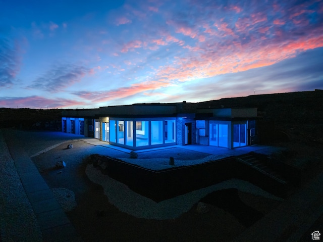 back house at dusk with a patio