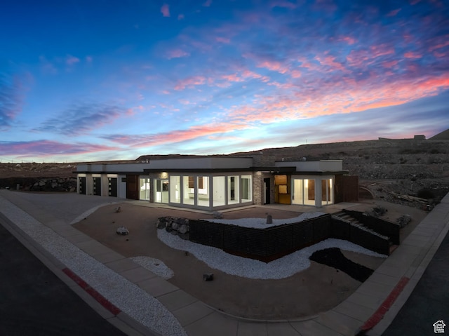 back house at dusk with a patio