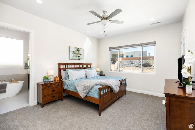 carpeted bedroom with ceiling fan and ensuite bath