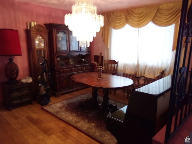 dining space with hardwood / wood-style flooring and a notable chandelier