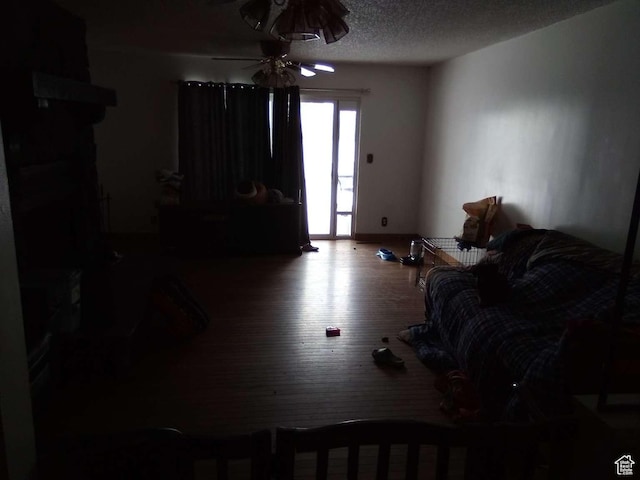 living room with ceiling fan, hardwood / wood-style floors, and a textured ceiling