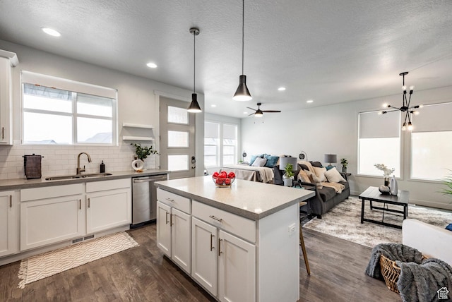 kitchen with sink, white cabinetry, decorative light fixtures, a center island, and stainless steel dishwasher