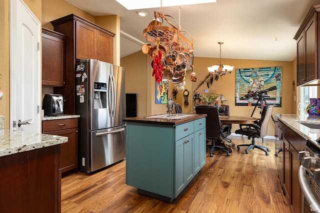 1361 S Roadrunner Cir, Kanab, UT 84741 - kitchen featuring lofted ceiling, stainless steel fridge, hanging light fixtures, a center island, and light stone counters