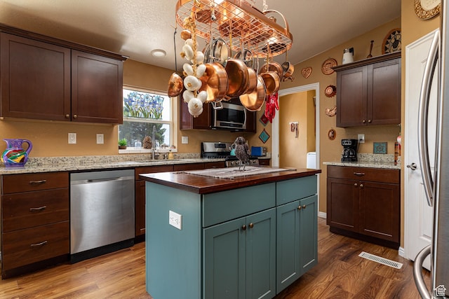 1361 S Roadrunner Cir, Kanab, UT 84741 - kitchen with appliances with stainless steel finishes, pendant lighting, sink, a center island, and light hardwood / wood-style flooring