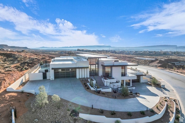 63 E Colima Rd, Washington, UT 84780 - view of front of house featuring a garage, driveway, stucco siding, and a mountain view