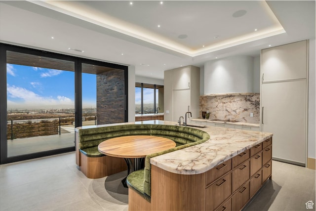 63 E Colima Rd, Washington, UT 84780 - kitchen with modern cabinets, a sink, a large island, black electric stovetop, and a tray ceiling