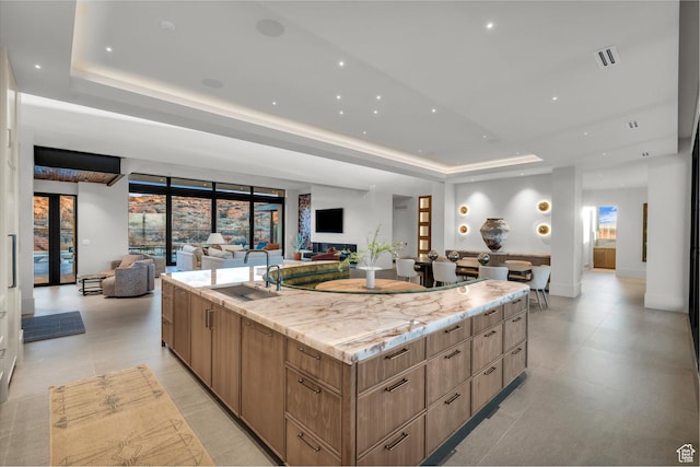 63 E Colima Rd, Washington, UT 84780 - kitchen with a tray ceiling, open floor plan, modern cabinets, a large island, and light stone counters