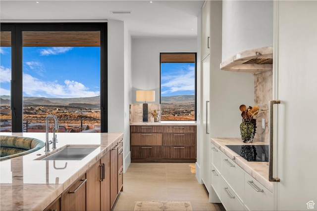 63 E Colima Rd, Washington, UT 84780 - kitchen featuring black electric cooktop, a mountain view, brown cabinetry, and light stone counters