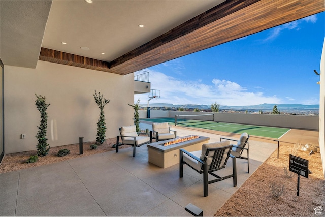 63 E Colima Rd, Washington, UT 84780 - view of patio with a fire pit, a mountain view, and a tennis court