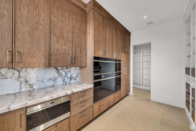 63 E Colima Rd, Washington, UT 84780 - kitchen featuring stainless steel microwave, decorative backsplash, light stone counters, beverage cooler, and brown cabinetry
