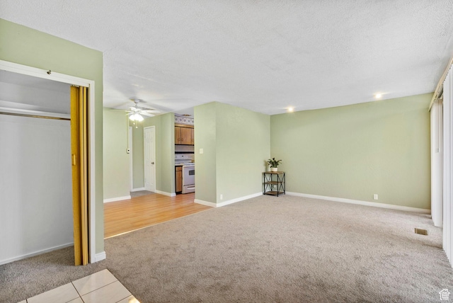 4409 S Rosehaven Ct Unit B, West Valley City, UT 84120 - unfurnished living room featuring a textured ceiling, a ceiling fan, baseboards, and light carpet