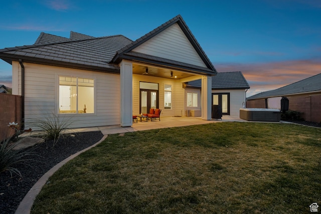 802 E Prairie Way, Washington, UT 84780 - back house at dusk featuring a yard, a hot tub, and a patio area