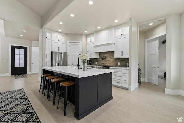 802 E Prairie Way, Washington, UT 84780 - kitchen with white cabinetry, light stone counters, high quality fridge, and a center island with sink