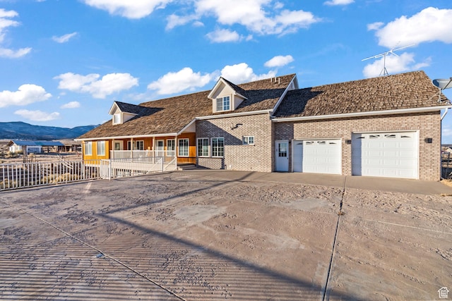 view of front facade featuring a garage, a mountain view, and covered porch