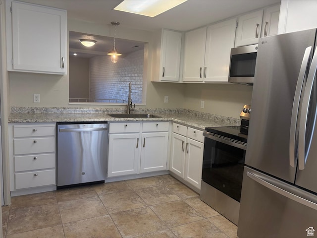 kitchen with pendant lighting, sink, white cabinets, stainless steel appliances, and light stone countertops