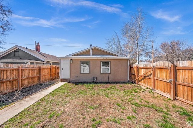 160 N Adams Ave E, Ogden, UT 84404 - back of house with a gate, a fenced backyard, and stucco siding